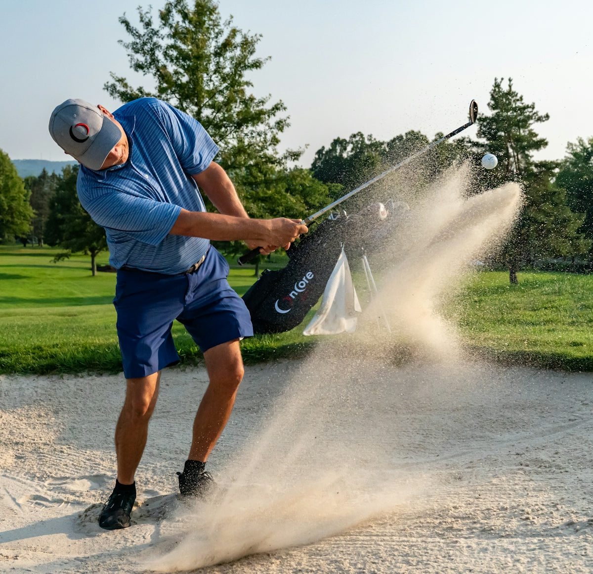 a man hitting sand with a golf club